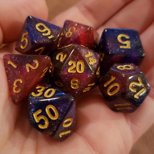 a pile of 7 polyhedral dice in a hand. The dice are purple and pink swirled with glitter, and have gold inked numbers.